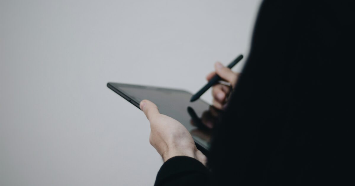 スタイラスペンでタブレットを操作する手元のアップ