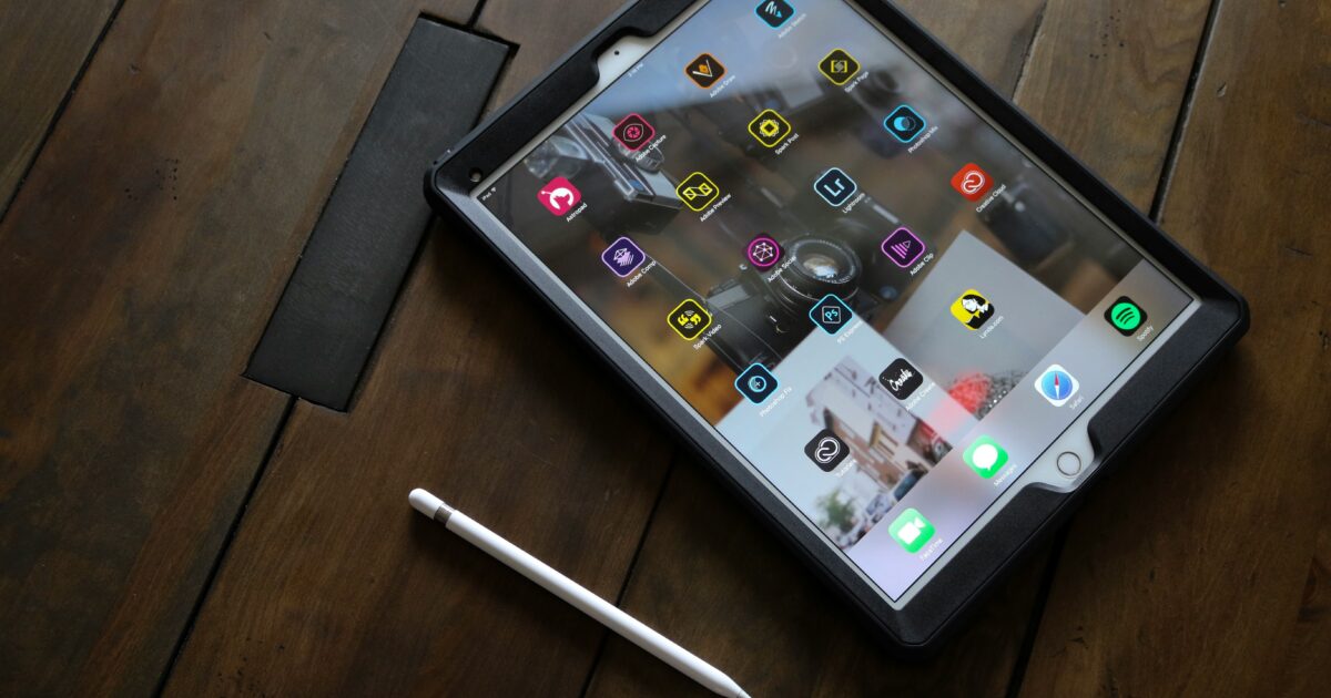木製テーブルに置かれたアプリ画面のタブレットとスタイラスペン