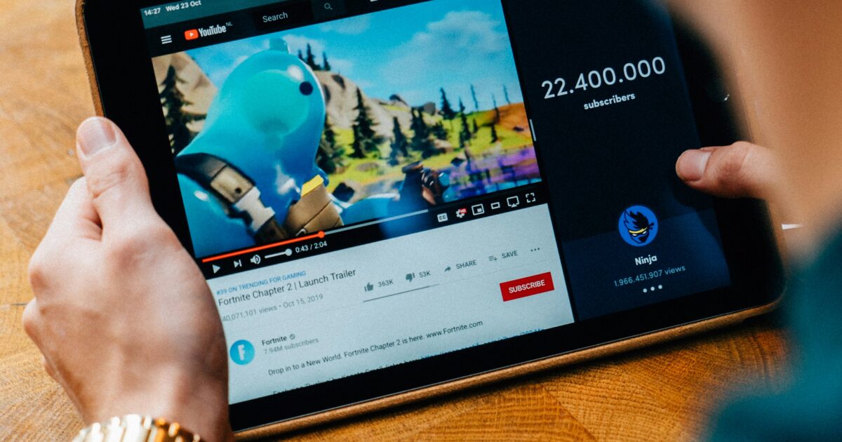 YouTubeで動画を再生中のタブレットを手に持つ様子