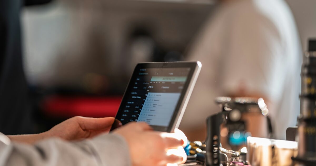 カフェのカウンターでタブレットを操作する手元のアップ