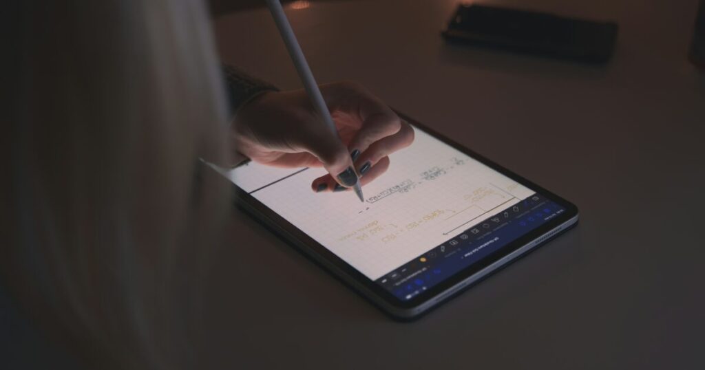 暗い室内で手書きノートを取るタブレットとスタイラスペン