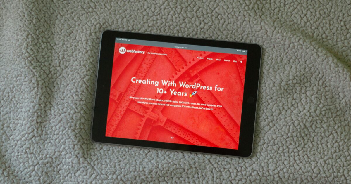 カーペットの上に置かれたWordPressのサイトを表示するタブレット