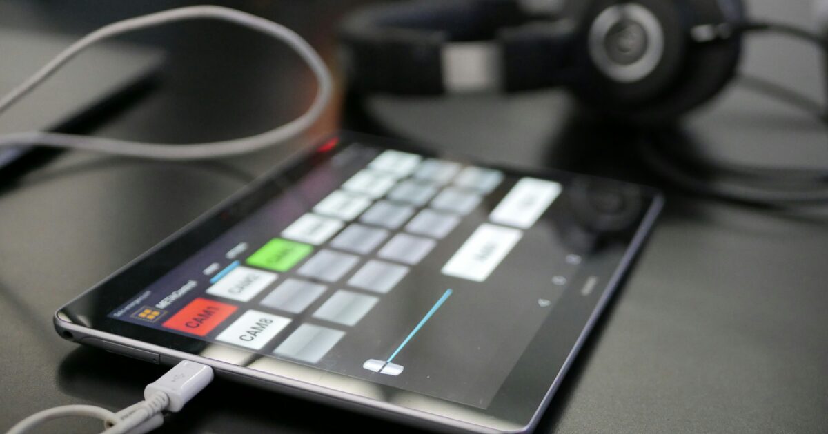 音声操作アプリを開いたタブレットとヘッドホンと接続ケーブル